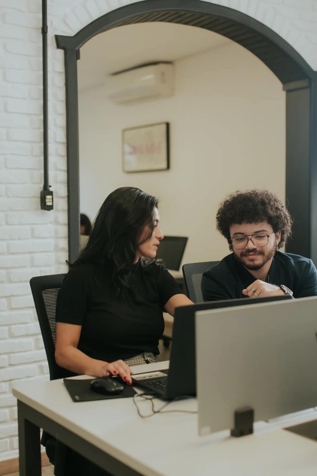 Dupla do time da INGAGE colaborando lado a lado no escritório